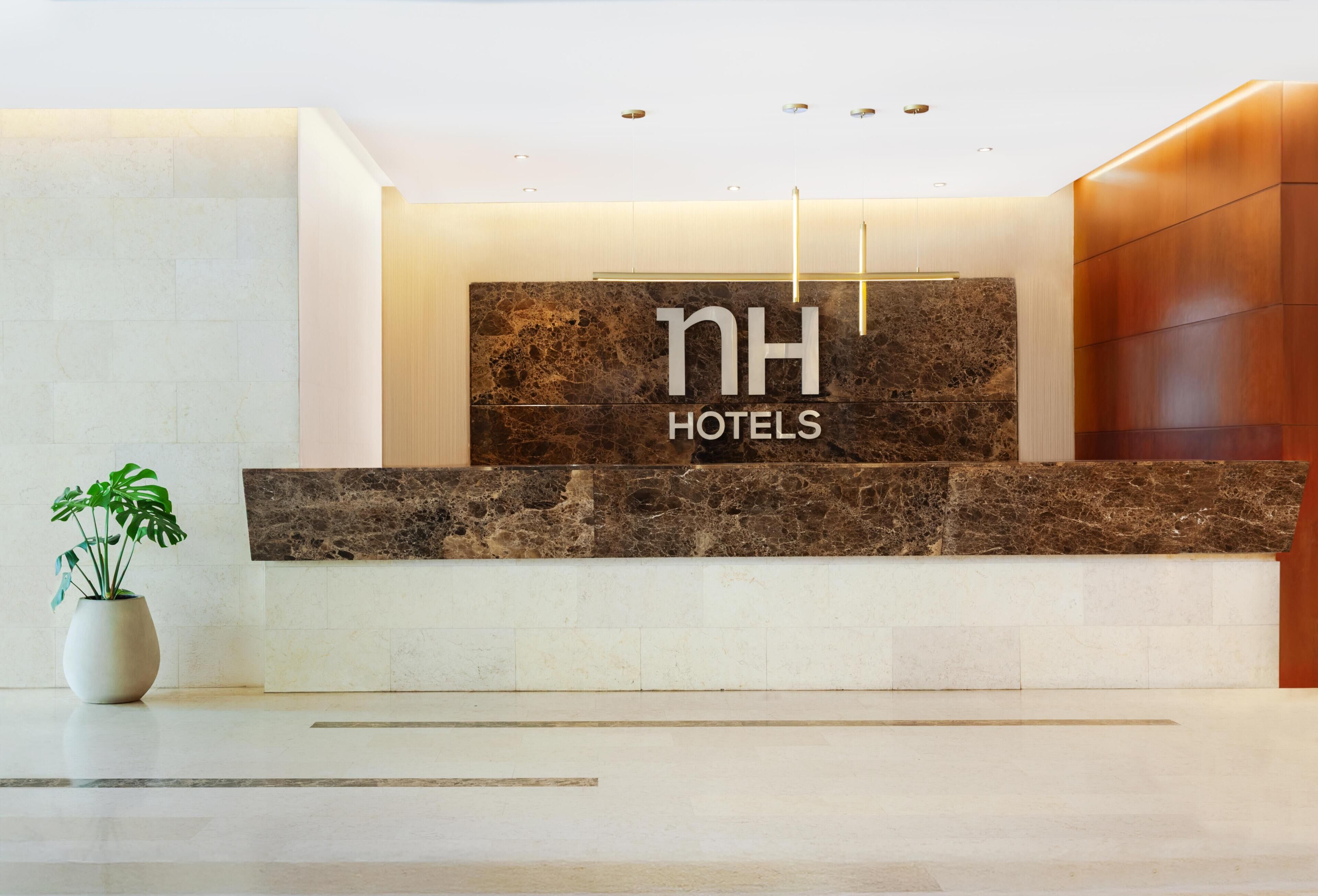 A reception desk with a marble top and a sign that reads 'NH HOTELS'.