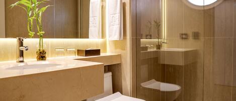 A modern bathroom with a toilet, sink, and glass-enclosed shower.