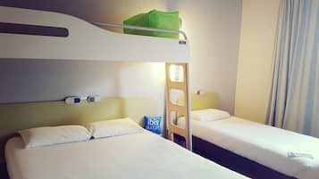 Ein Hotelzimmer mit zwei Betten, einem Etagenbett und einer grünen Tasche im oberen Bett.