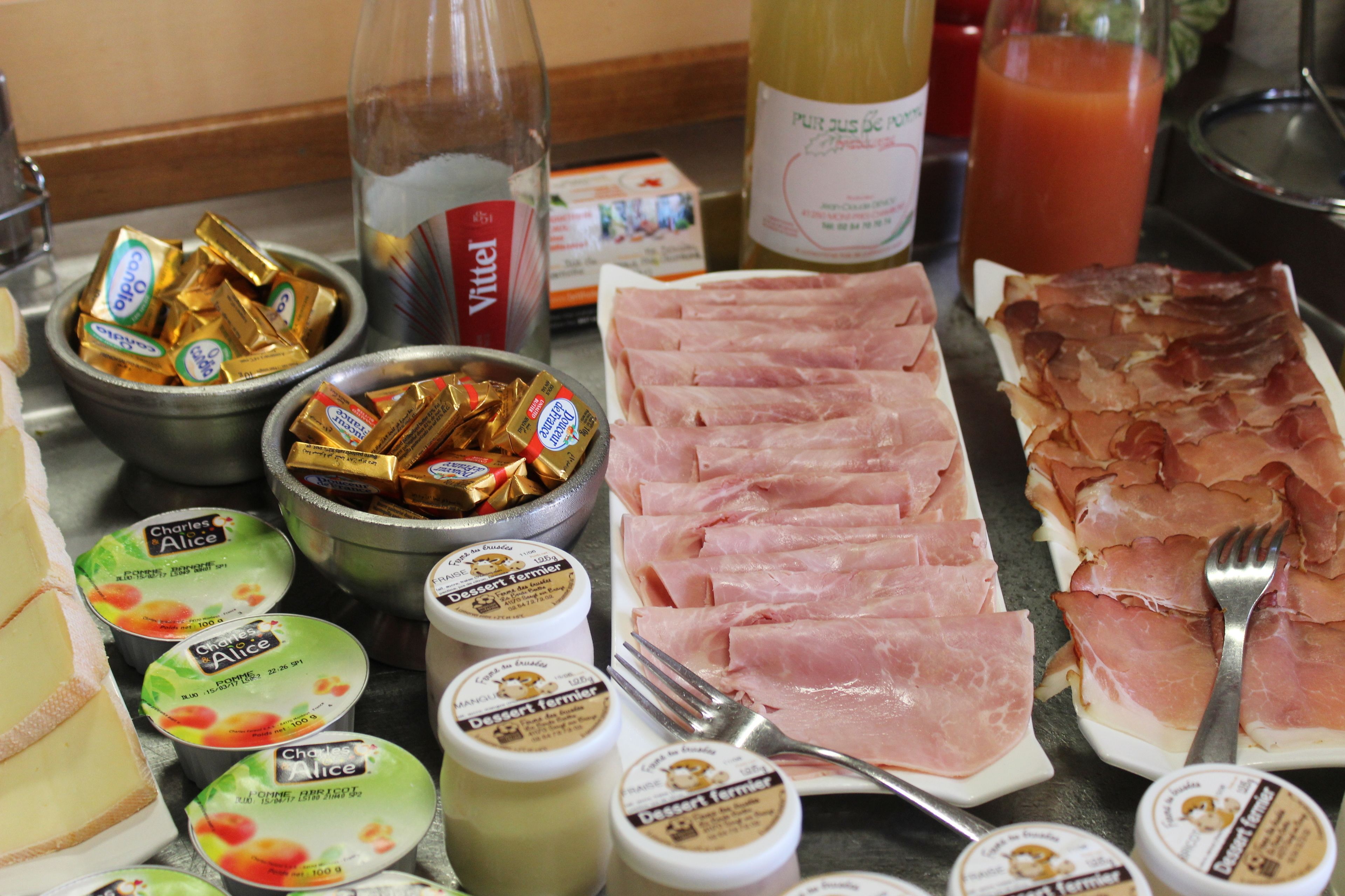 A breakfast buffet with various food items including ham, cheese, and chocolate bars.