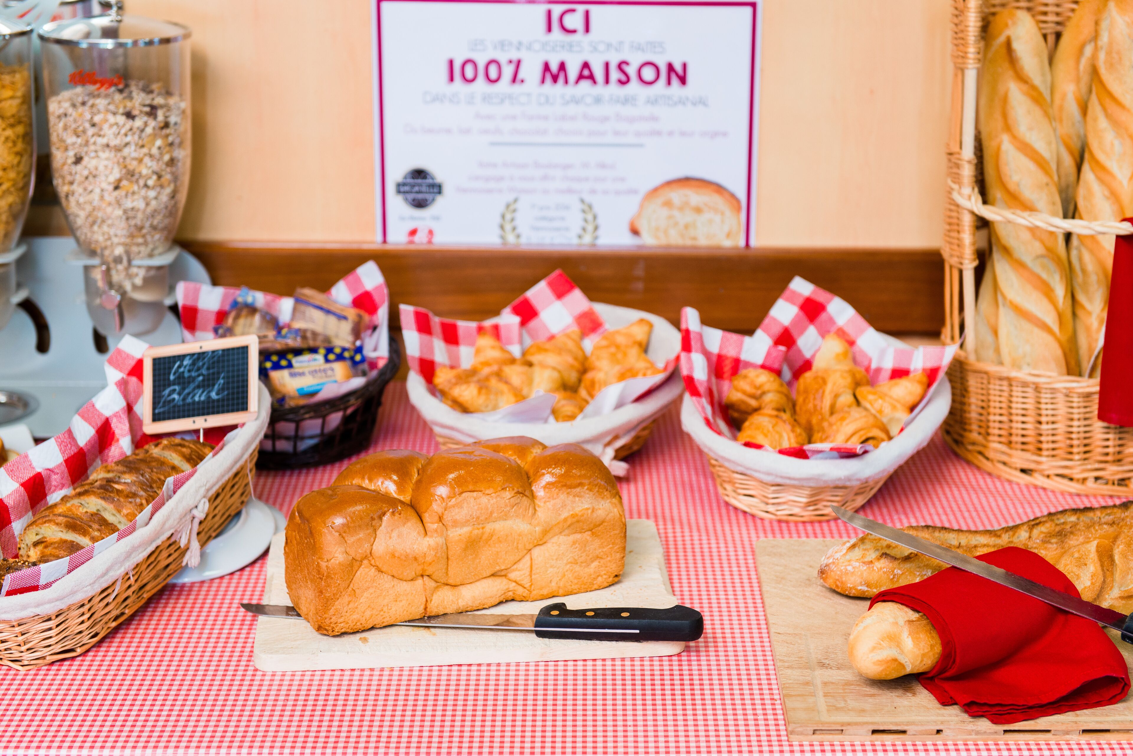 A table with various baked goods, including bread and pastries, on a checkered tablecloth.