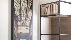 A room with a wooden bookshelf and a framed historical photograph of a building's interior.
