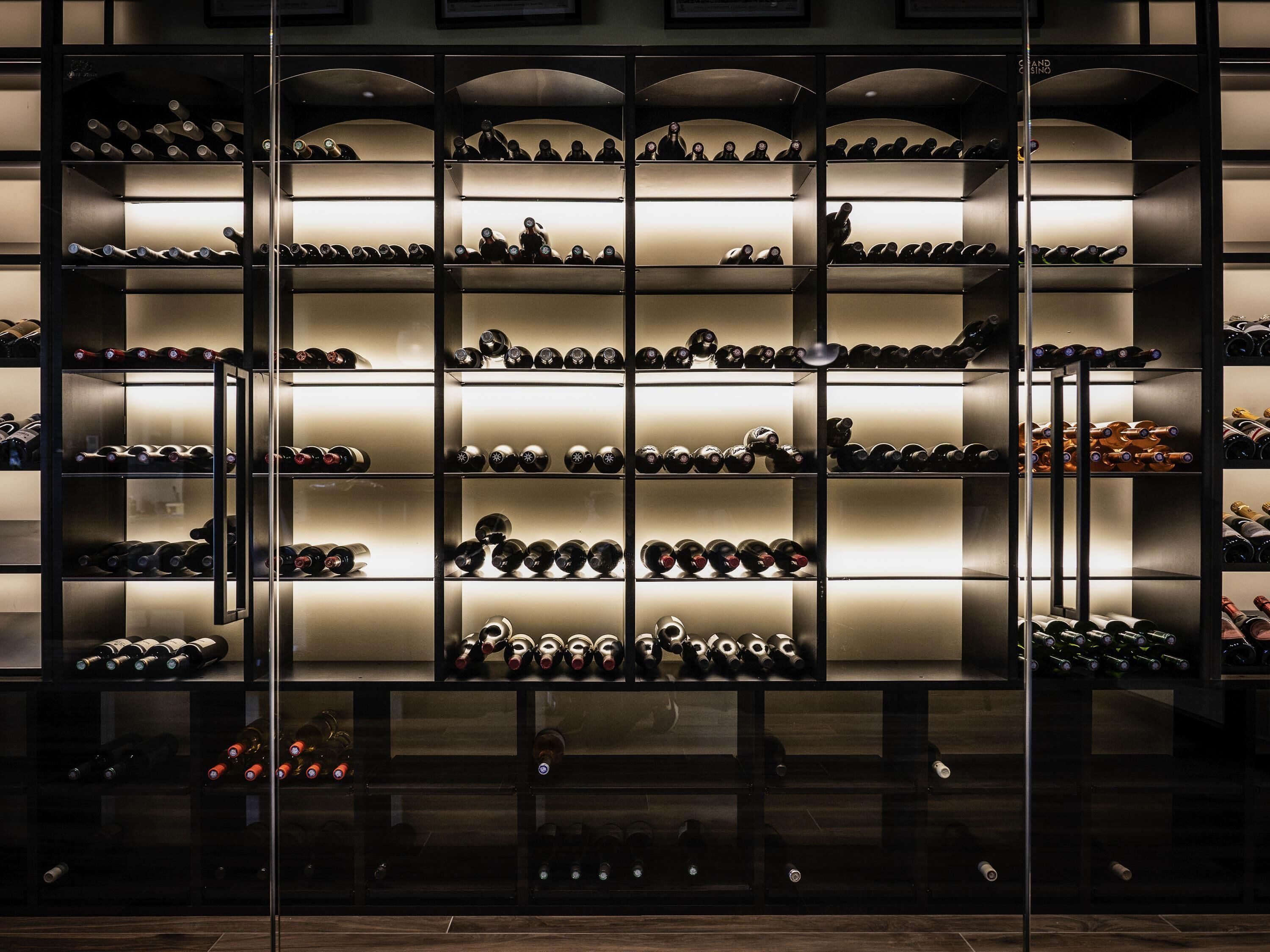 A wine cellar with multiple shelves and racks for storing wine bottles.