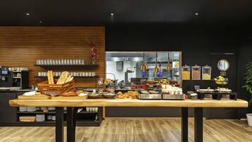 A buffet setup with various food items and a coffee machine.