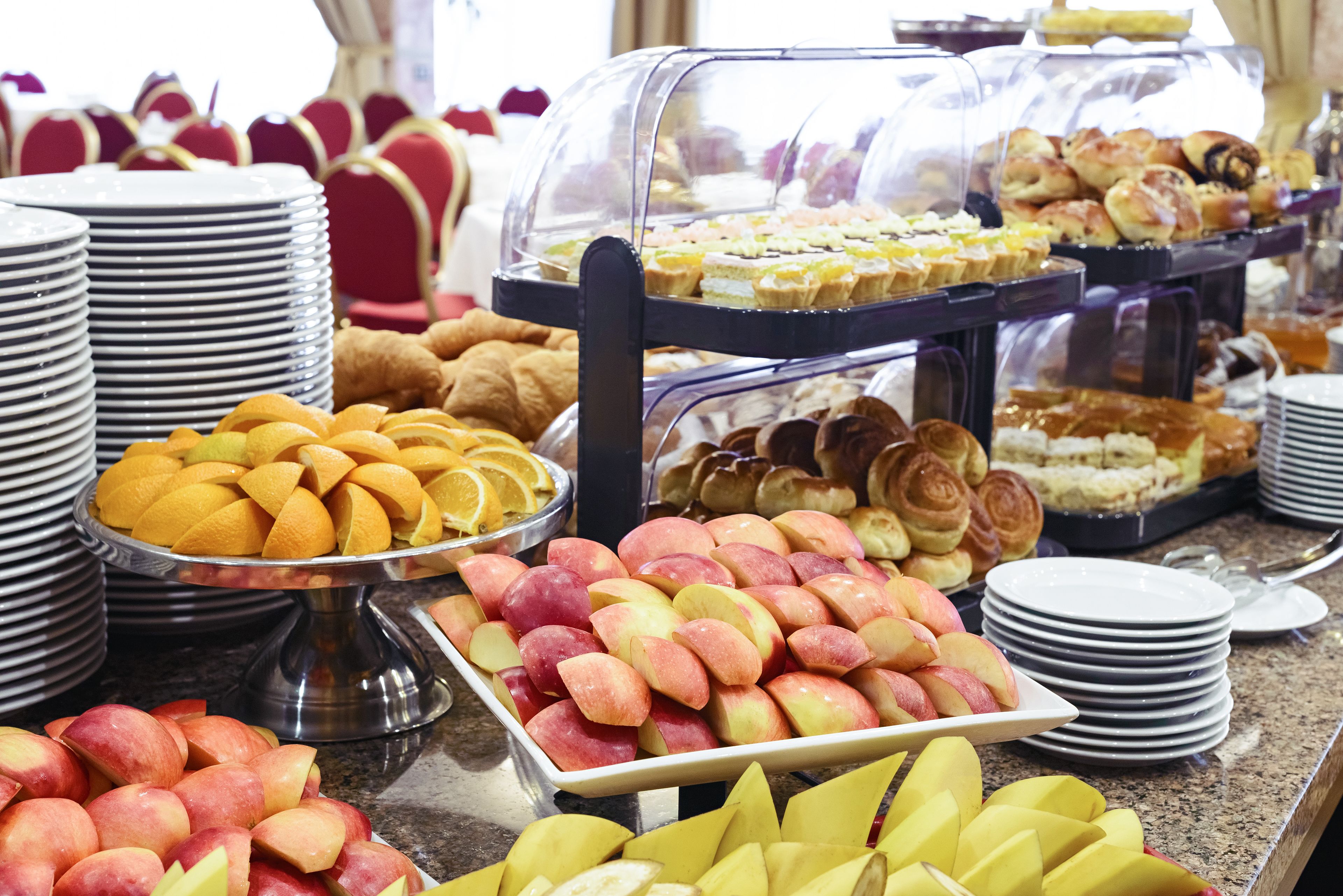 Un bufé con diversas frutas y pasteles.