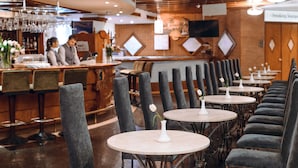 Un restaurant doté d’un bar, de plusieurs tables et de chaises.