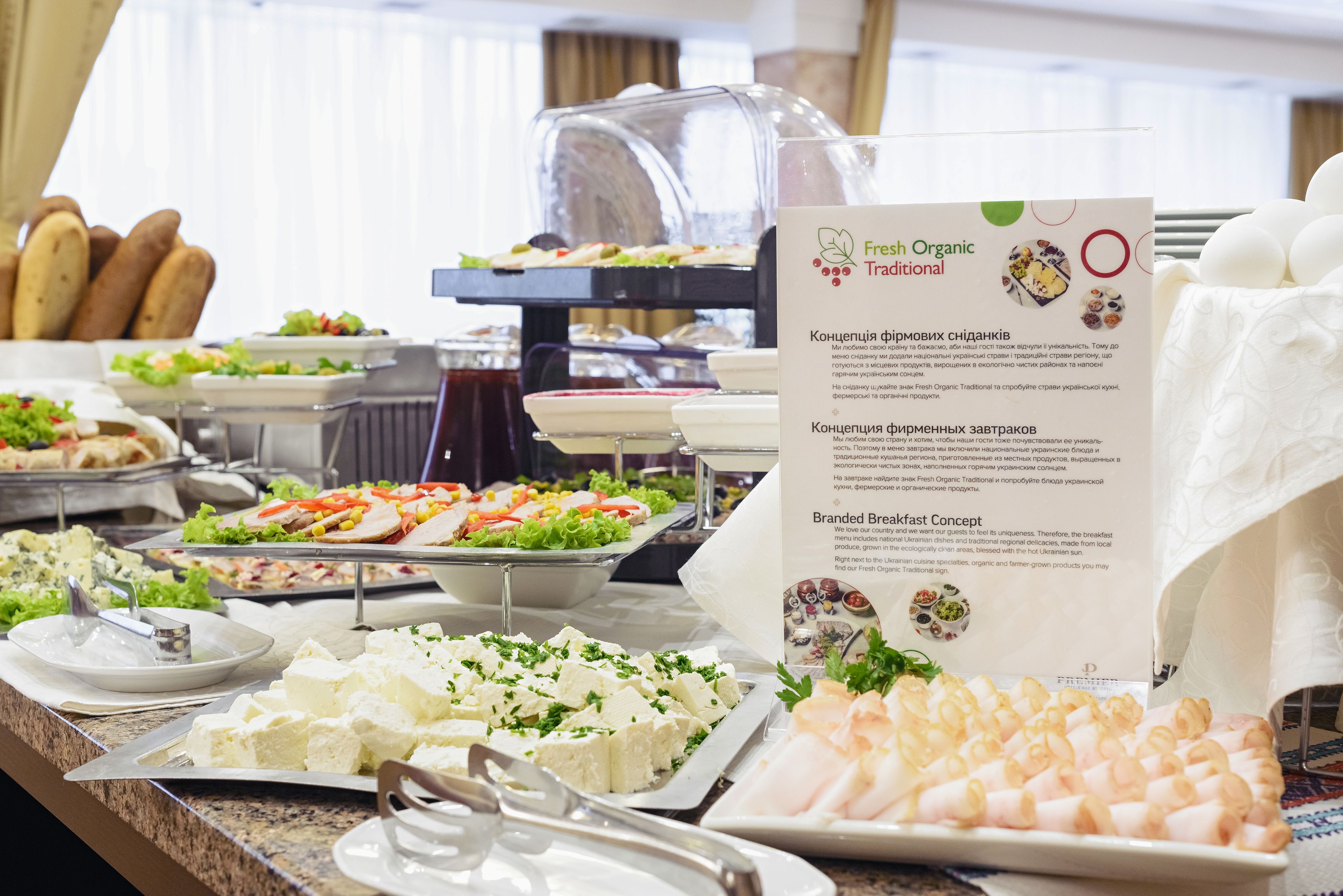 A buffet with various food items including bread, salads, and cheese.