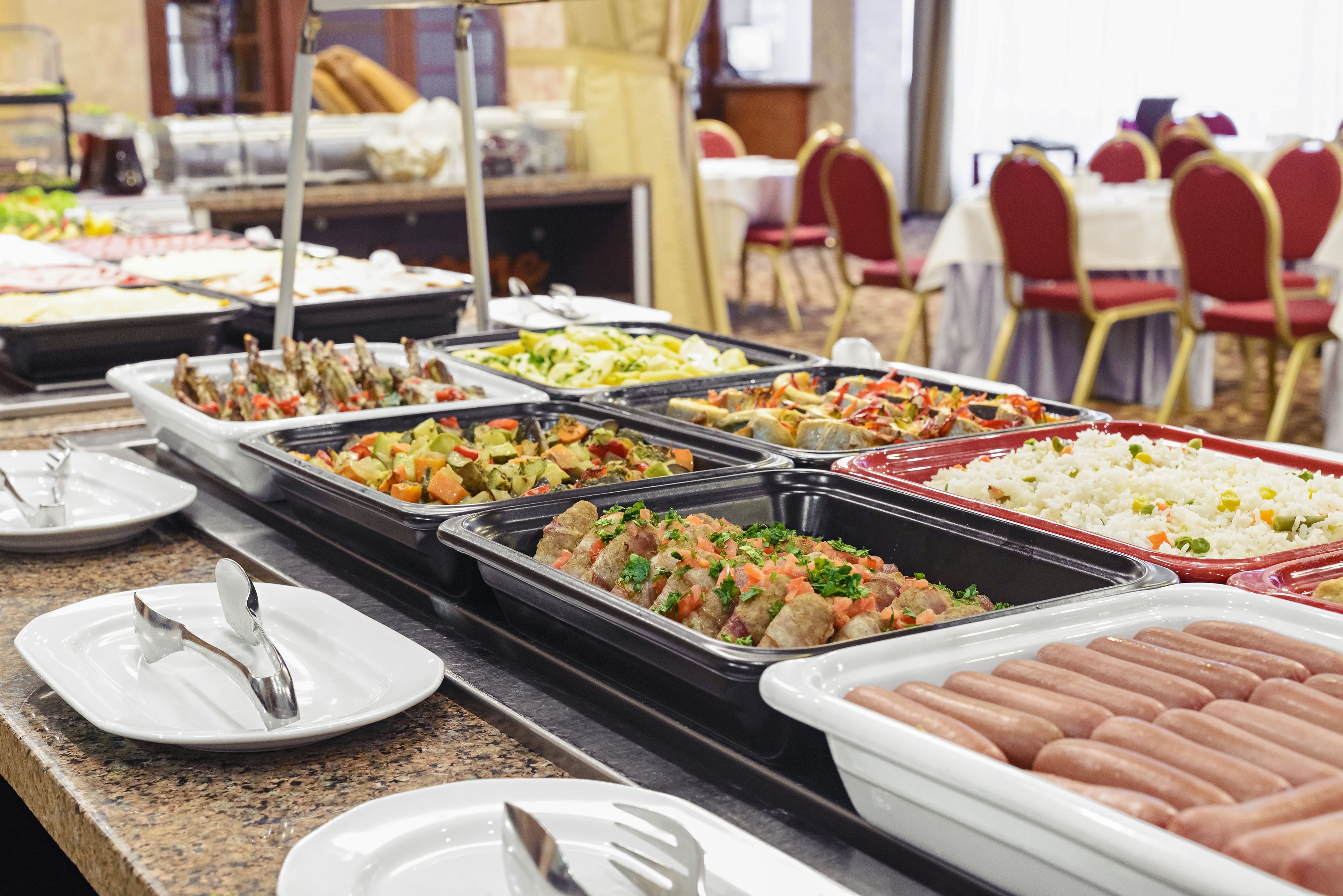 A buffet with various food options including meats, vegetables, and rice.