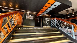 A staircase with wooden railings and a sign indicating the Admiral Hotel Milano.