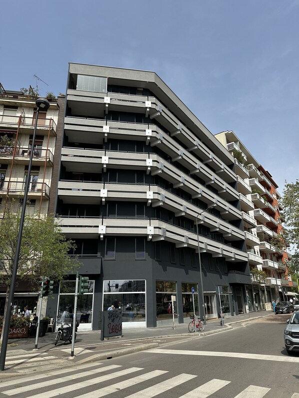 A multi-story parking garage with a modern design, featuring balconies and a pedestrian walkway at the ground level. - Admiral Hotel (Milan)