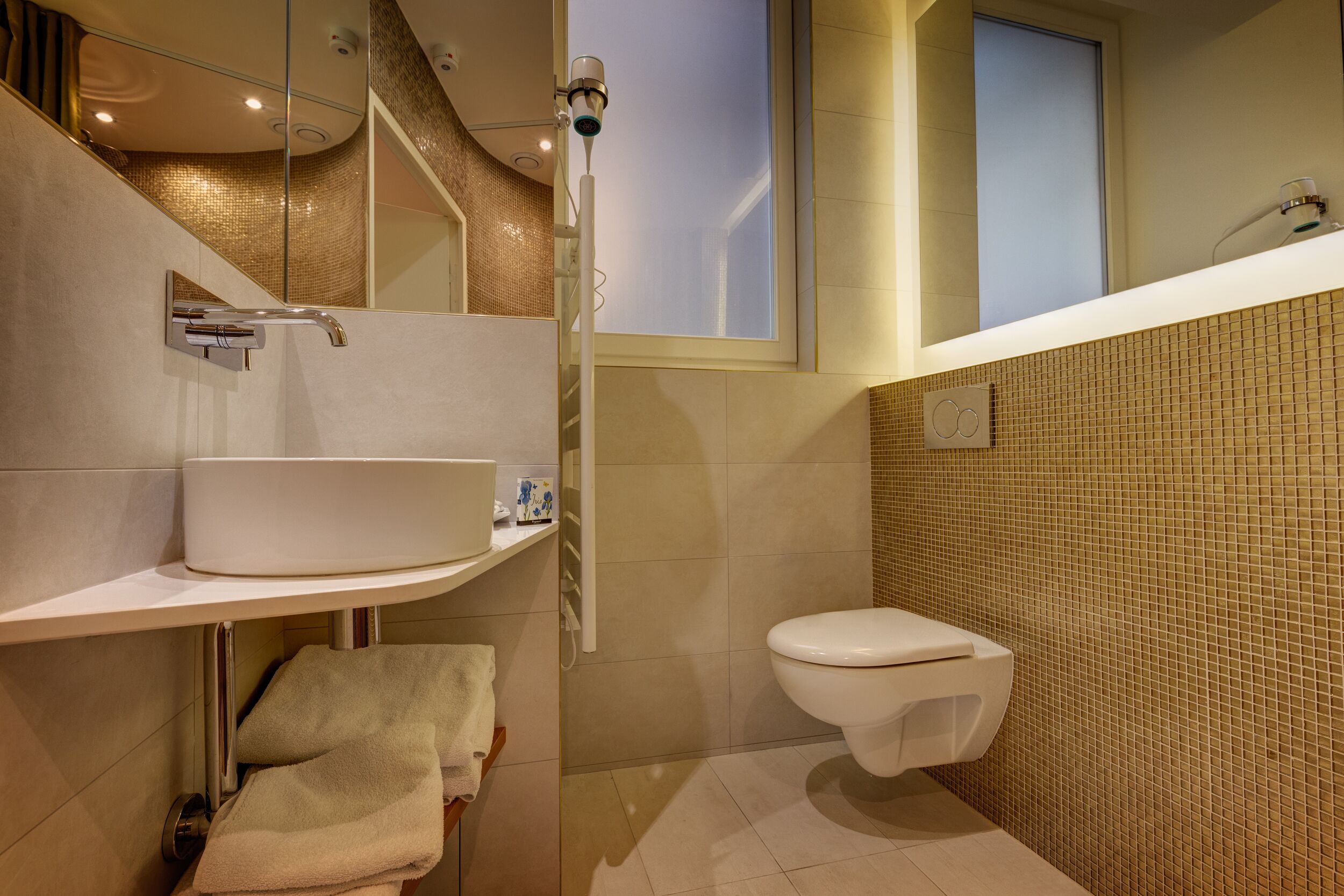 Un baño moderno con un lavamanos blanco, un inodoro y una zona de ducha.