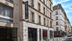 Un hotel con fachada clásica, ventanas amplias y un llamativo letrero que dice 'HOTEL'.