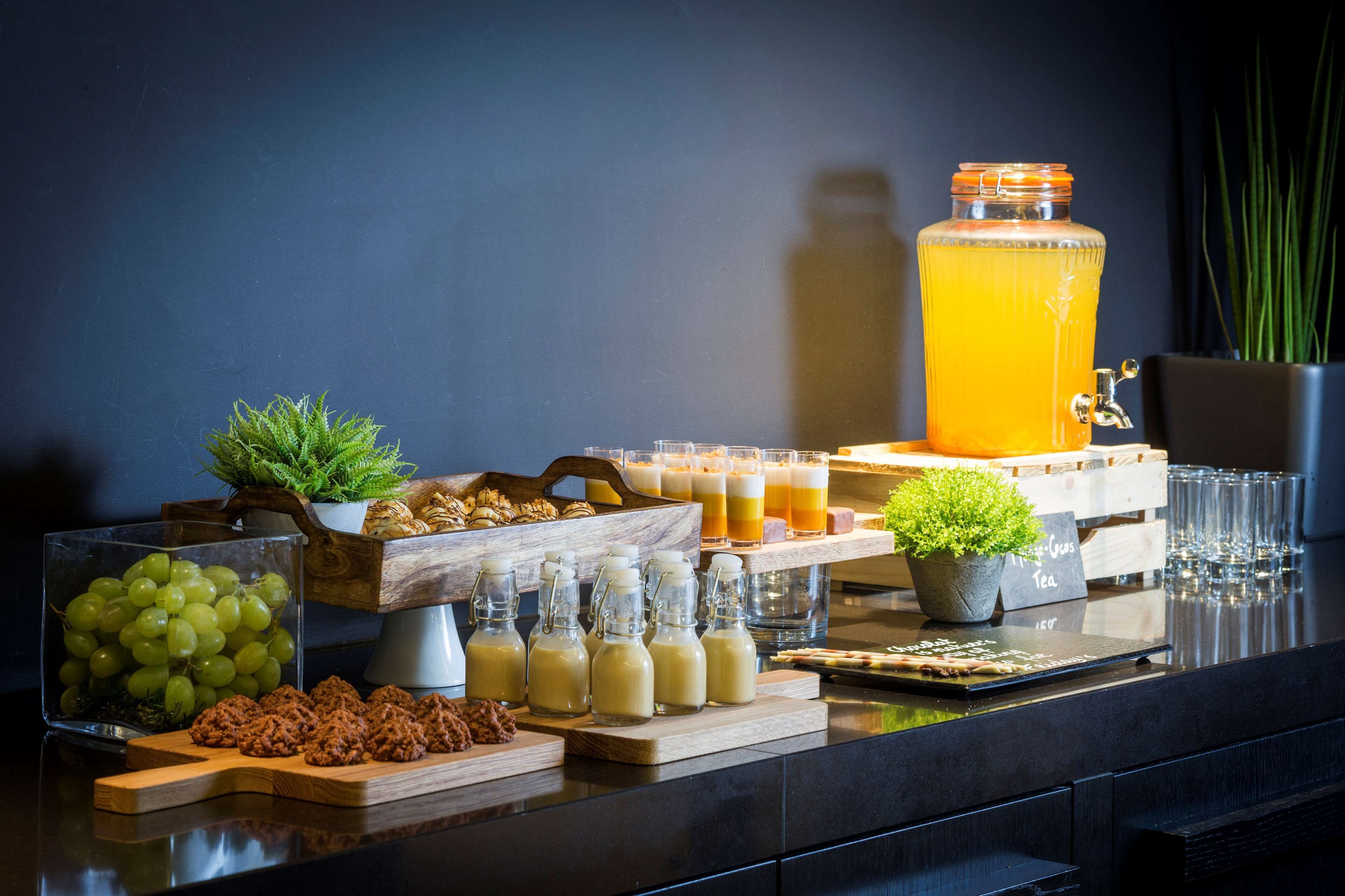Ein reichhaltiges Buffet mit verschiedenen Speisen, Getränken und einem großen Glasbehälter mit Orangensaft.