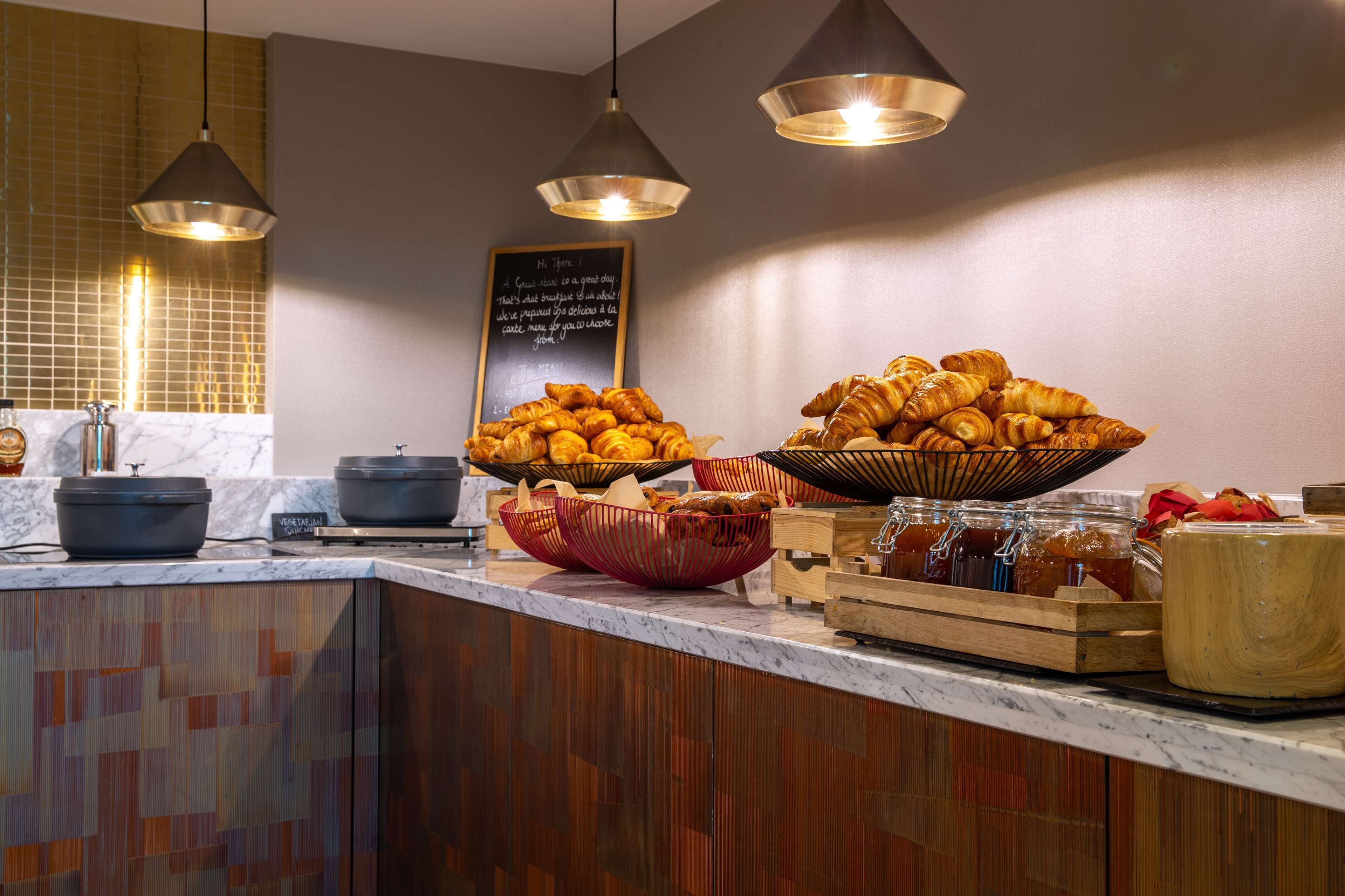 Ein Frühstücksbuffet mit Croissants, Marmeladen und verschiedenen Backwaren.