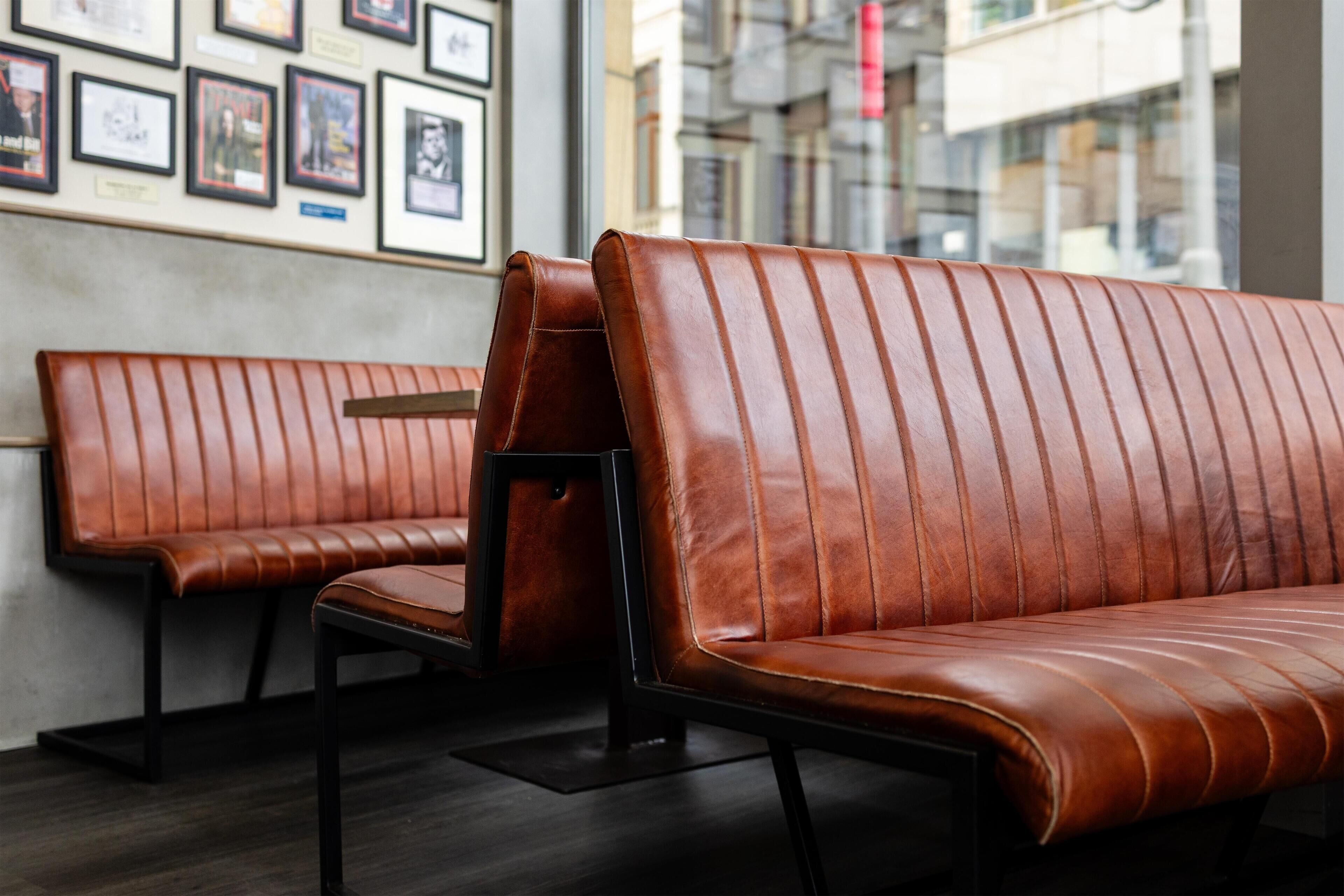 A modern interior with leather sofas and a wall adorned with framed pictures.