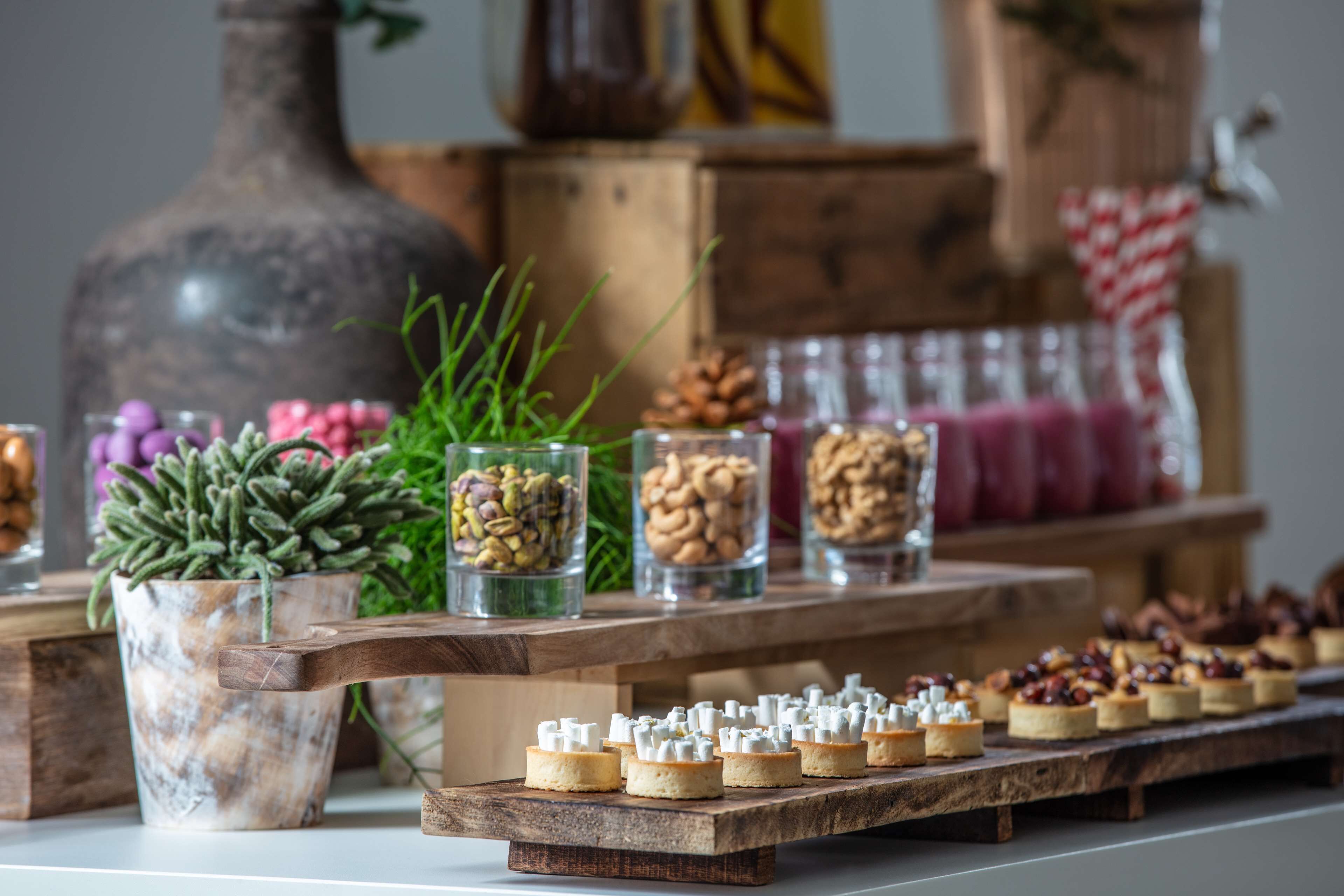 Une table en bois sur laquelle sont disposés divers aliments et des bocaux décoratifs.