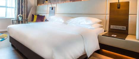 Una habitación de hotel moderna con una cama grande, una mesita de noche, una lámpara y un panel de control en la pared.