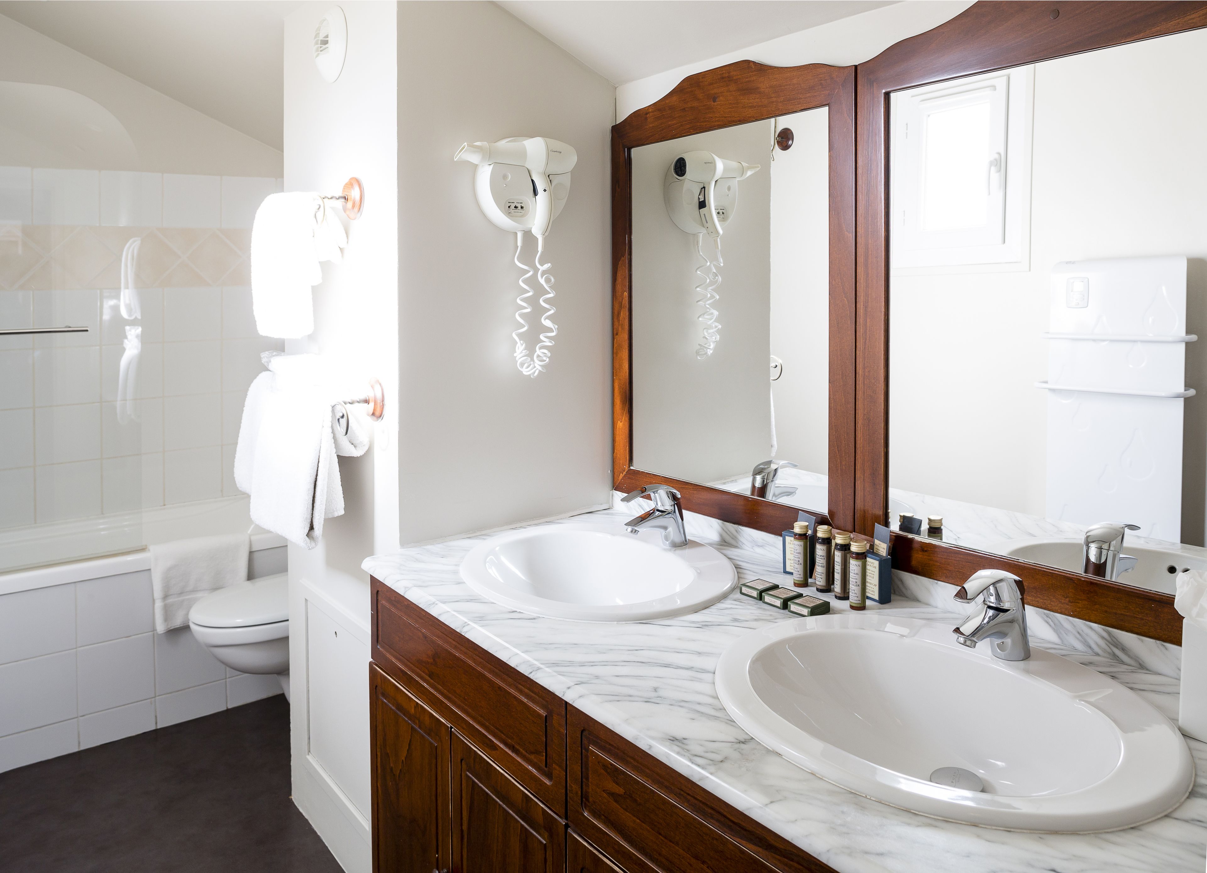 designer toiletries, hair dryer, slippers, towels