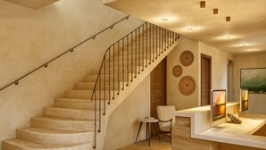 A staircase with a metal railing, a small round table, and two chairs in a room with a wooden desk and two monitors. - Hotel de l'Horloge (Avignon)