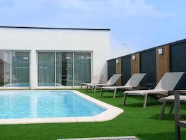 Una piscina al aire libre de temporada, sombrillas