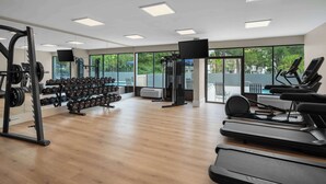 Une salle de sport équipée de tapis de course, d’haltères et d’appareils de musculation.
