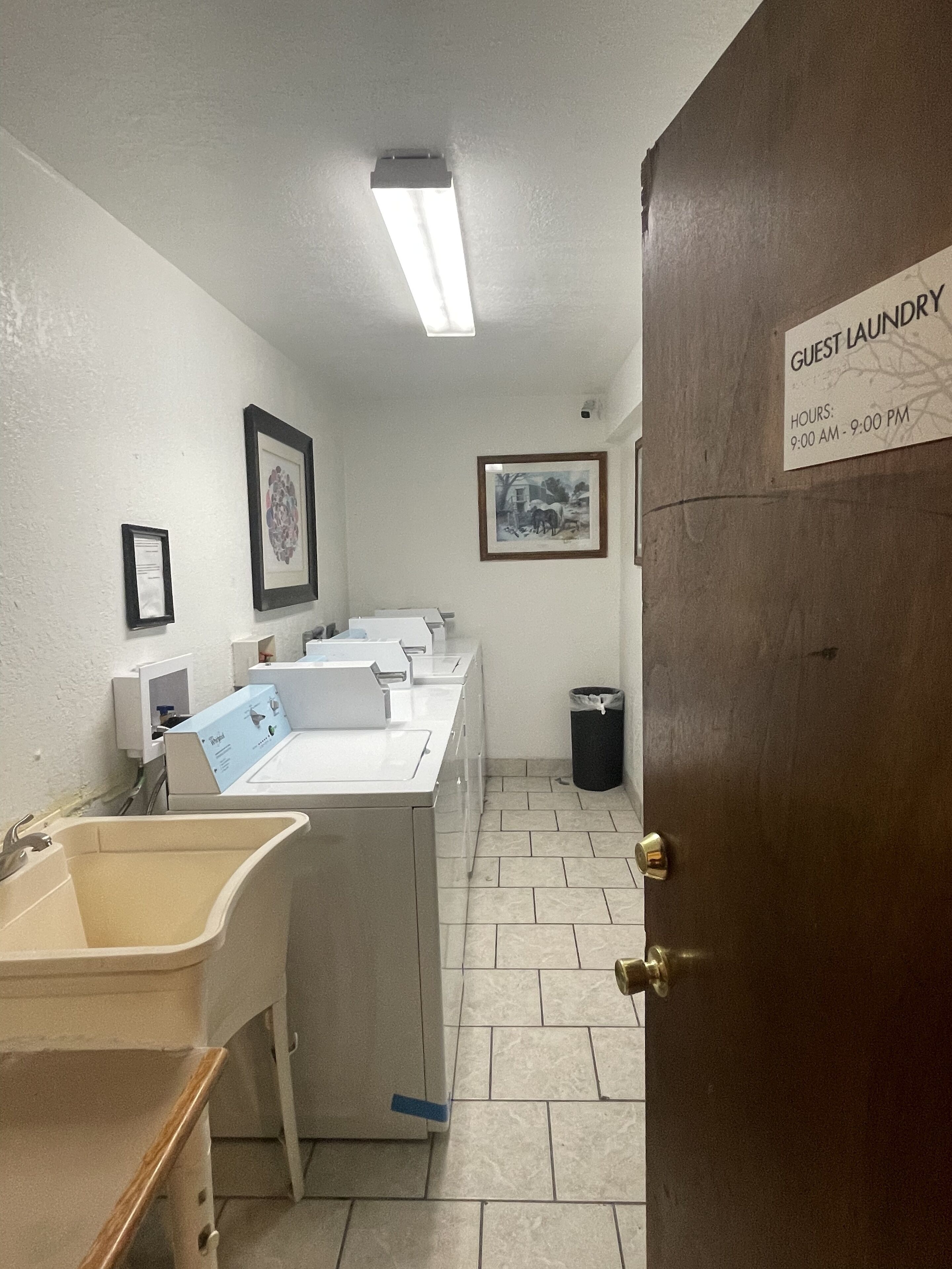 A guest laundry area with a sign indicating hours of operation.