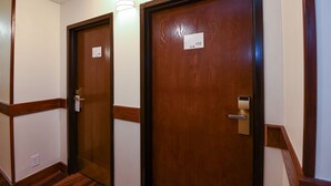 Un pasillo con dos puertas de madera, cada una con una placa de número.