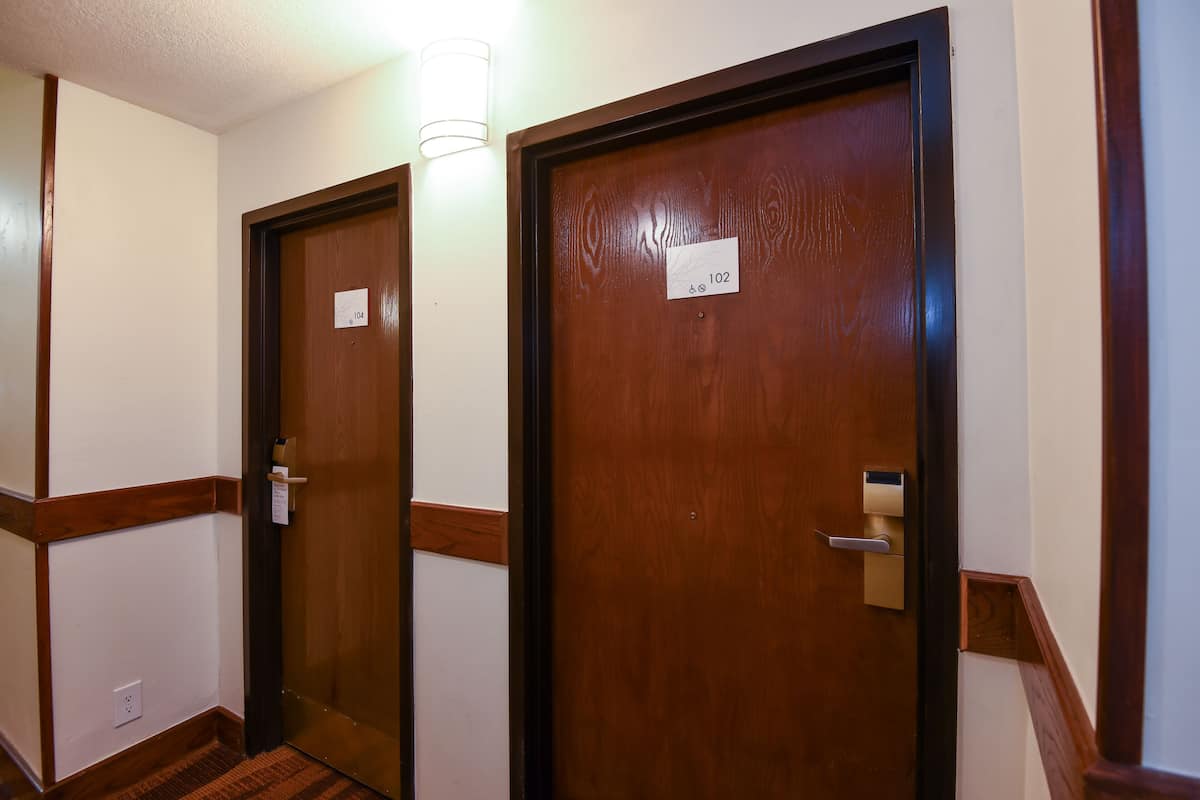 A hallway with two wooden doors, each with a number plate.