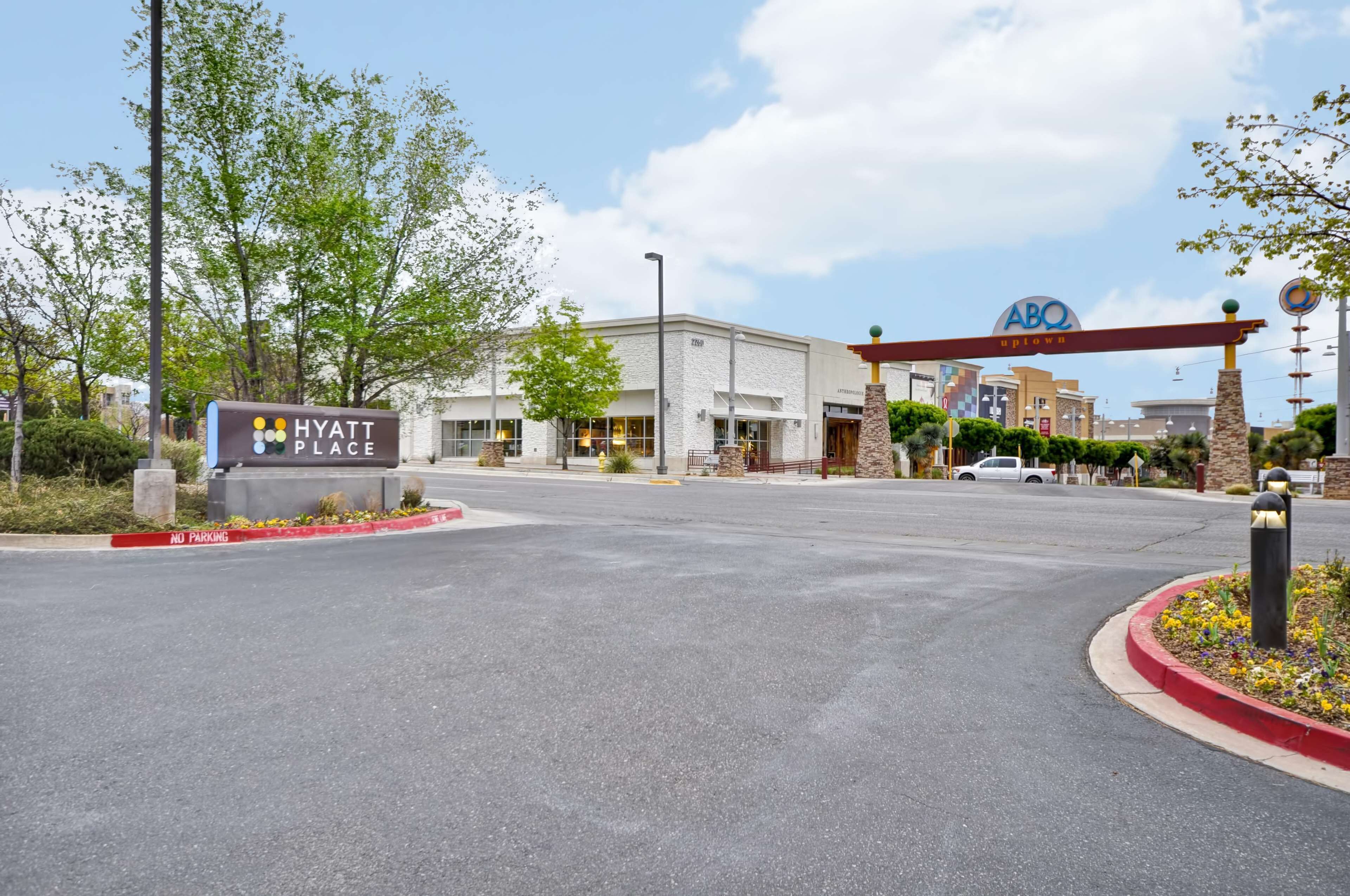 A Hyatt Place hotel entrance with a sign, a parking lot, and a Target store in the background.