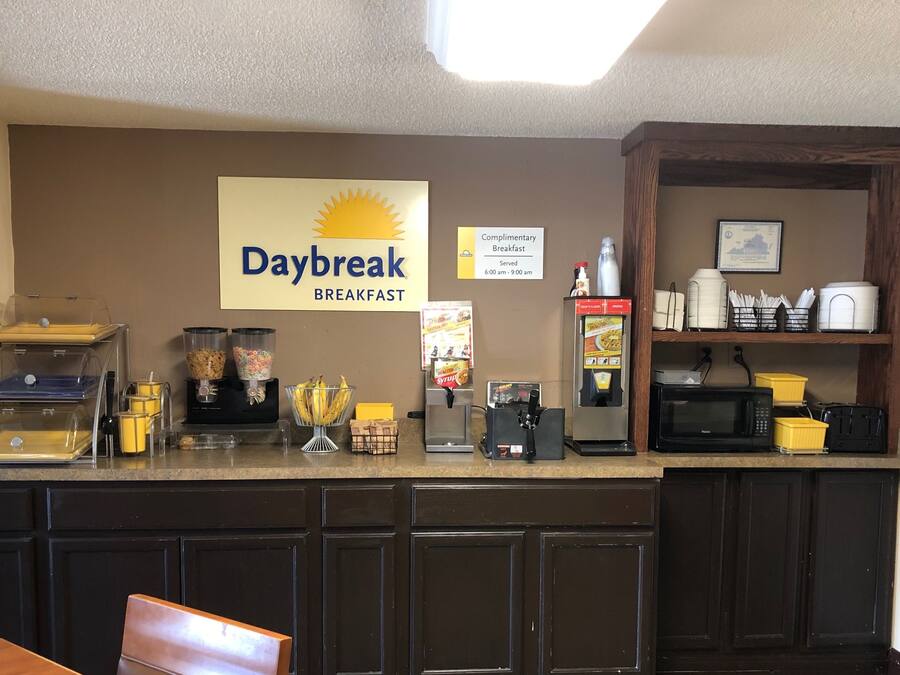 A breakfast bar with a sign reading "Daybreak Breakfast," a coffee machine, a microwave, and various food containers.