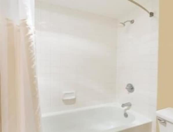 A bathroom with a bathtub, a toilet, and a shower area. - Days Inn by Wyndham Tappahannock (Tappahannock)