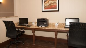 A conference room with a granite table, two laptops, a printer, and two black office chairs. - Holiday Inn Express Vernon - Manchester by IHG (Vernon)