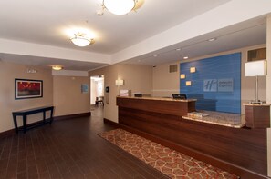 A hotel reception area with a reception desk, a phone, and a sign for Holiday Inn Express. - Holiday Inn Express Vernon - Manchester by IHG (Vernon)