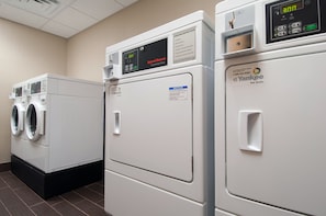 A row of commercial dryers in a laundry facility. - Holiday Inn Express Vernon - Manchester by IHG (Vernon)