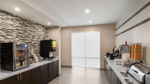Une cuisine moderne équipée d’un espace de libre-service, d’un réfrigérateur et d’une machine à café.