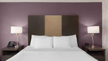 A hotel room with a bed, two bedside tables, lamps, and a telephone on one of the tables.