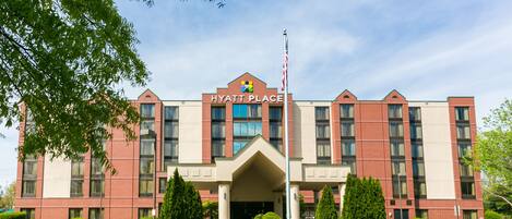 Un edificio de ladrillo con una entrada amplia y un letrero que dice 'HYATT PLACE'.