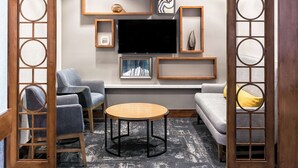 A modern living room with a sofa, chairs, a coffee table, and a flat-screen TV mounted on the wall. - Hyatt Place Nashville/Franklin/Cool Springs (Franklin)