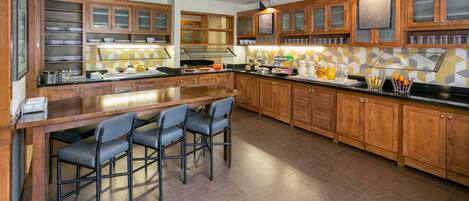 Una cocina moderna con armarios de madera, una isla central con taburetes altos y un salpicadero de azulejos.