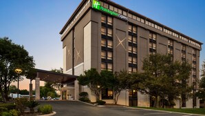Un edificio de Holiday Inn Express con un diseño moderno, ventanas amplias y un área de entrada techada.
