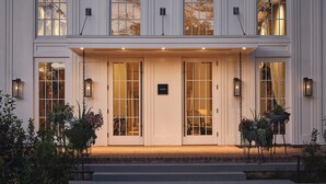 A two-story building with a symmetrical facade, large glass doors, and a brick-paved entrance. - Faraway Martha's Vineyard (Edgartown)