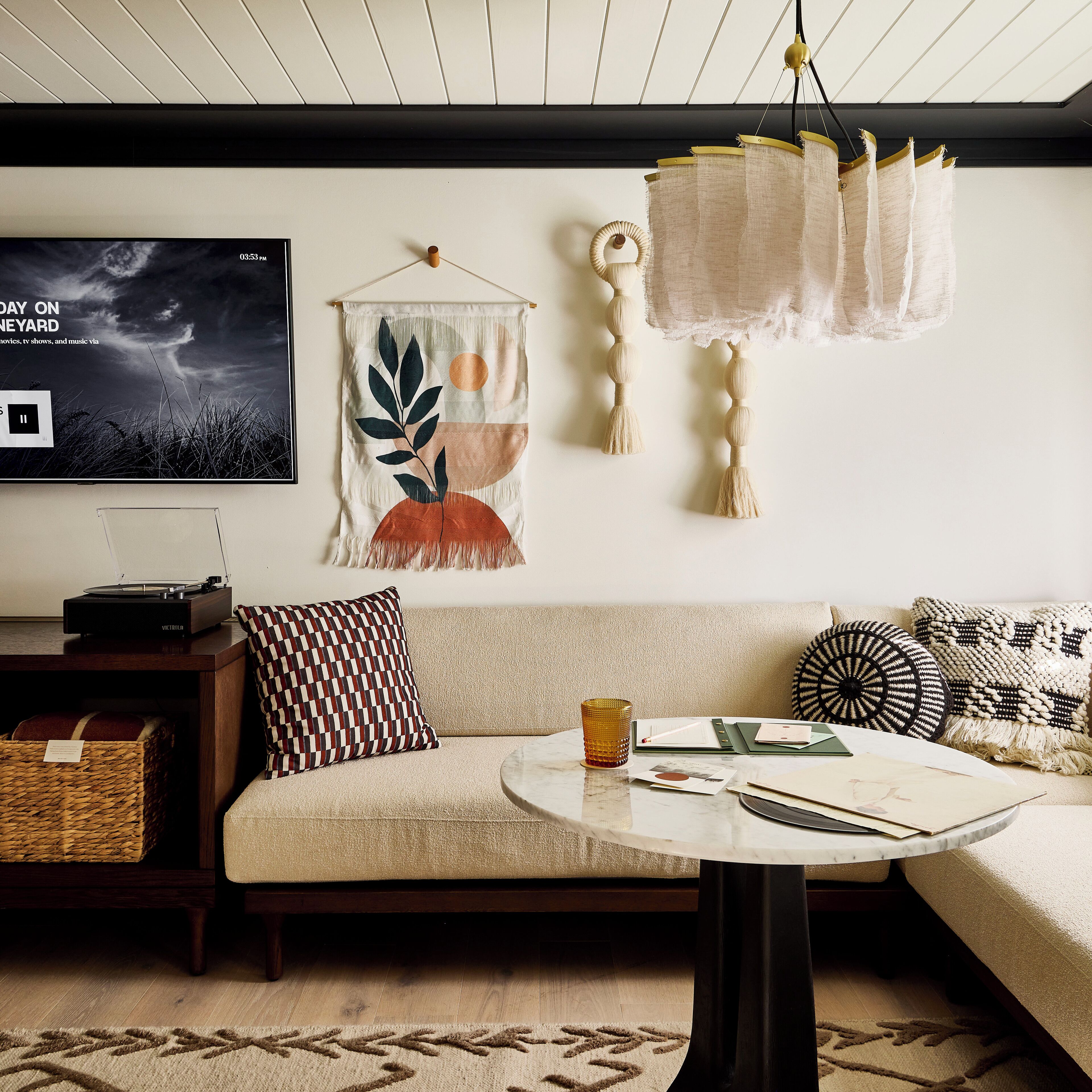 A cozy living room with a sofa, a coffee table, and a television displaying a movie.