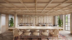 A spacious dining area with a long table surrounded by wicker chairs, wooden panel walls, and large windows. - Faraway Martha's Vineyard (Edgartown)