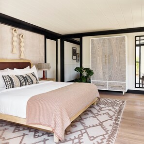 Relax in a stylish bedroom with a large bed, nightstand, and potted plant.