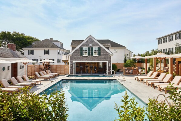 Relax by the pool surrounded by lounge chairs and lush greenery.