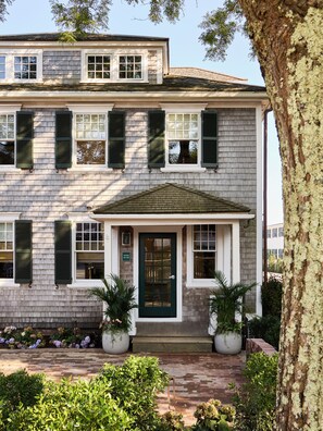 Stunning two-story building with a central entrance, green door, and white-framed windows.
