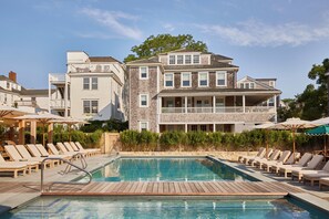 Relax by the pool surrounded by lounge chairs and umbrellas.