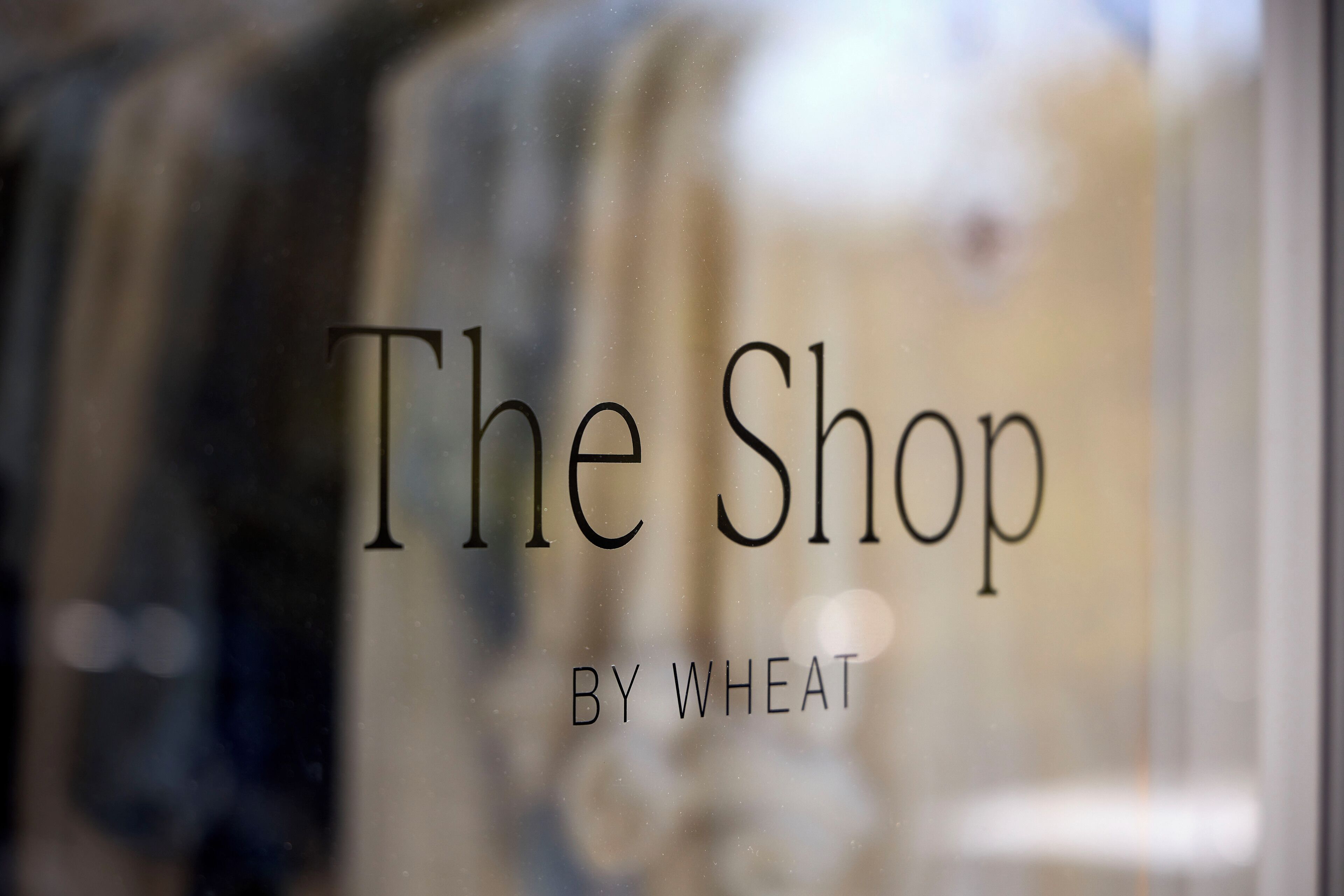 Una finestra amb el text “The Shop by Wheat” visible.