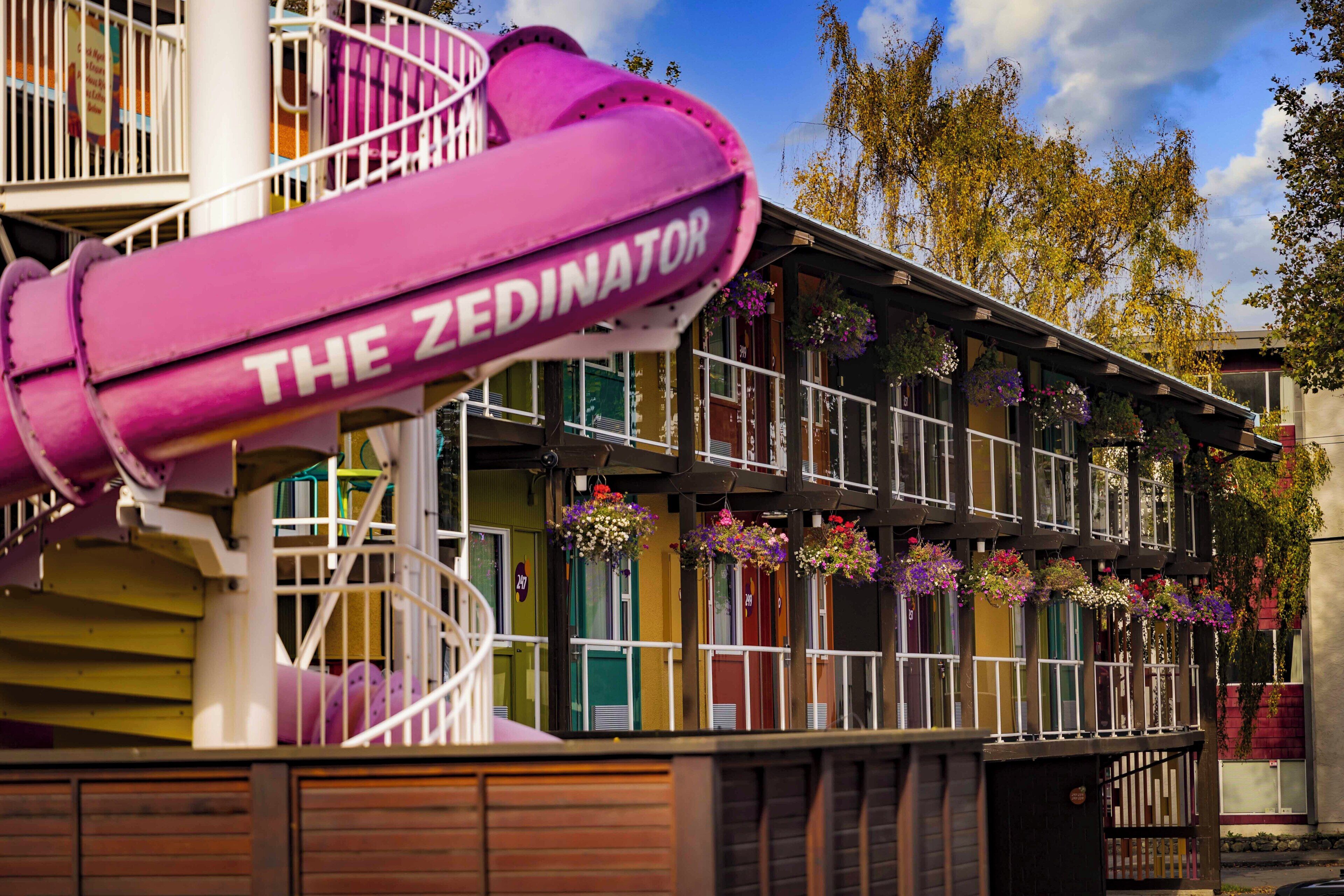 Un bâtiment aux couleurs vives, doté d’un escalier en colimaçon et de jardinières suspendues.