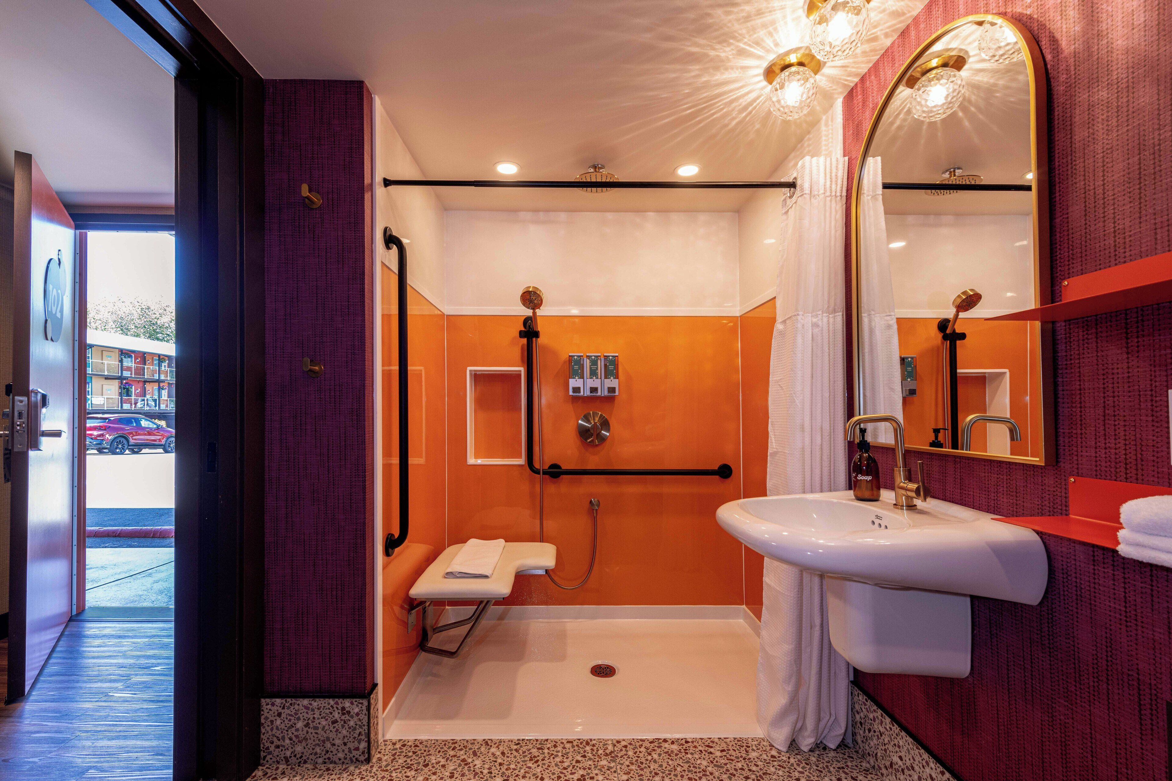 A modern bathroom with a walk-in shower, a white sink, and a large mirror.